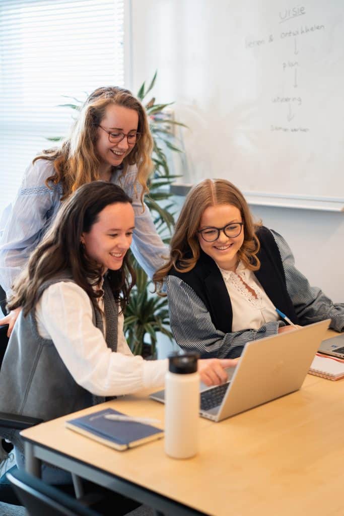 linksvoor Anne de Rouw (met donker haar) in gesprek met 2 collega's achter een laptop